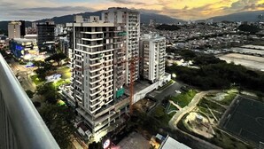 A high-rise building complex with multiple floors, surrounded by a cityscape and a river. - LUXURY APARTMENT IN THE GOLDEN MILE OF IBAGUÉ, COLOMBIA. (Ibagué)
