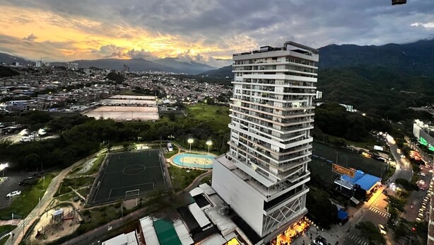 A high-rise building with multiple balconies, surrounded by a cityscape and mountains. - LUXURY APARTMENT IN THE GOLDEN MILE OF IBAGUÉ, COLOMBIA. (Ibagué)