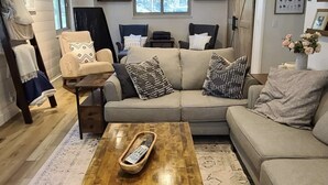 A cozy living room with a wooden coffee table, a beige sofa, and a patterned rug. - Iconic modern A-frame steps from lake and pet friendly (Carnelian Bay)