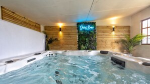 Un jacuzzi con pared de madera y un letrero de neón que dice "Dives Born".