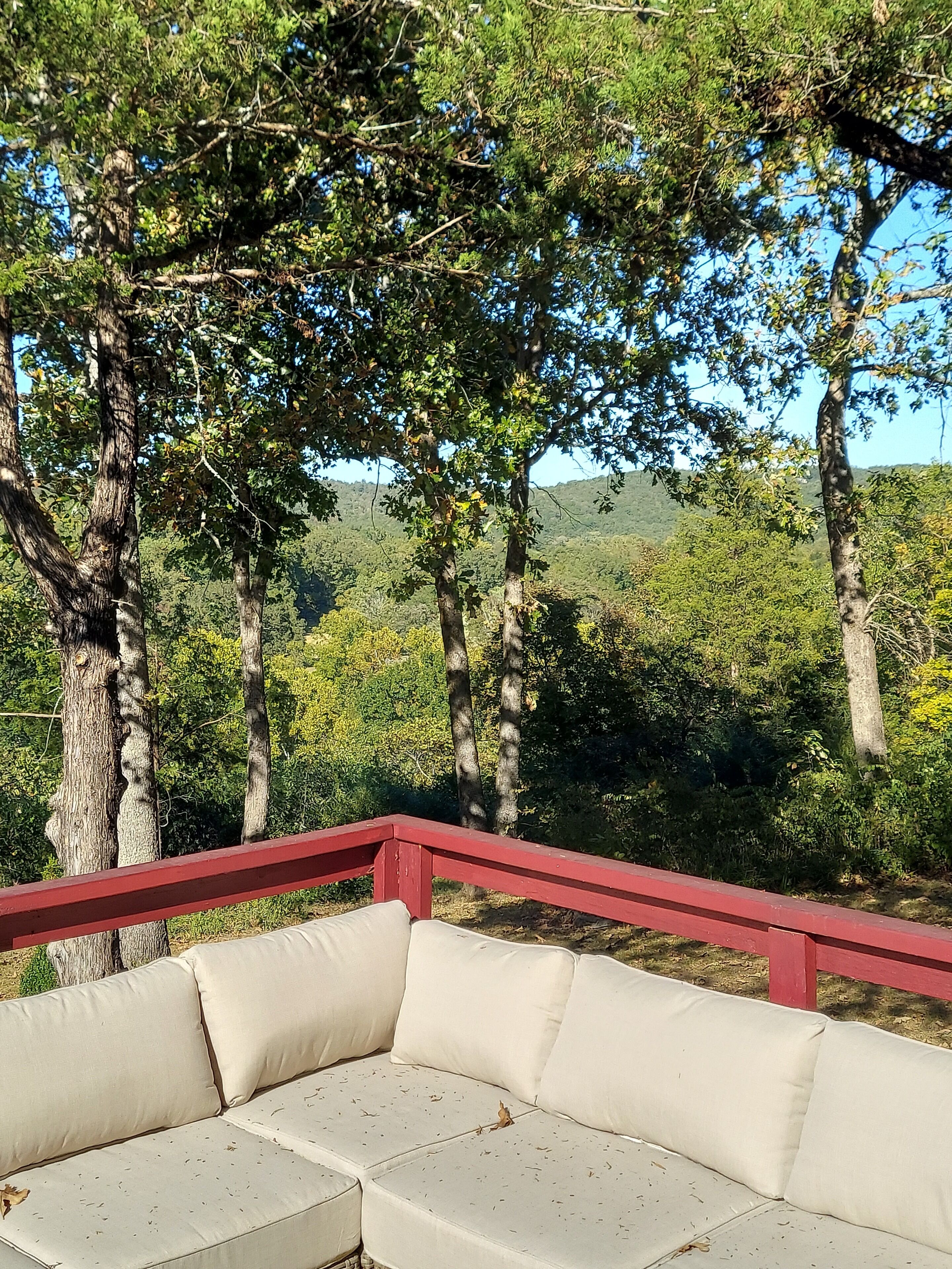 A red-framed outdoor seating area with a beige cushioned sofa.