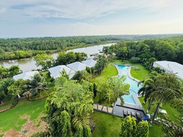 Um resort com piscina, vários quartos de hóspedes e vista para o rio.