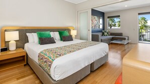 A modern hotel room with a large bed, a sofa, and a dining table. - The Sand Resort Kingscliff - One Bed (8308) (Tweed)