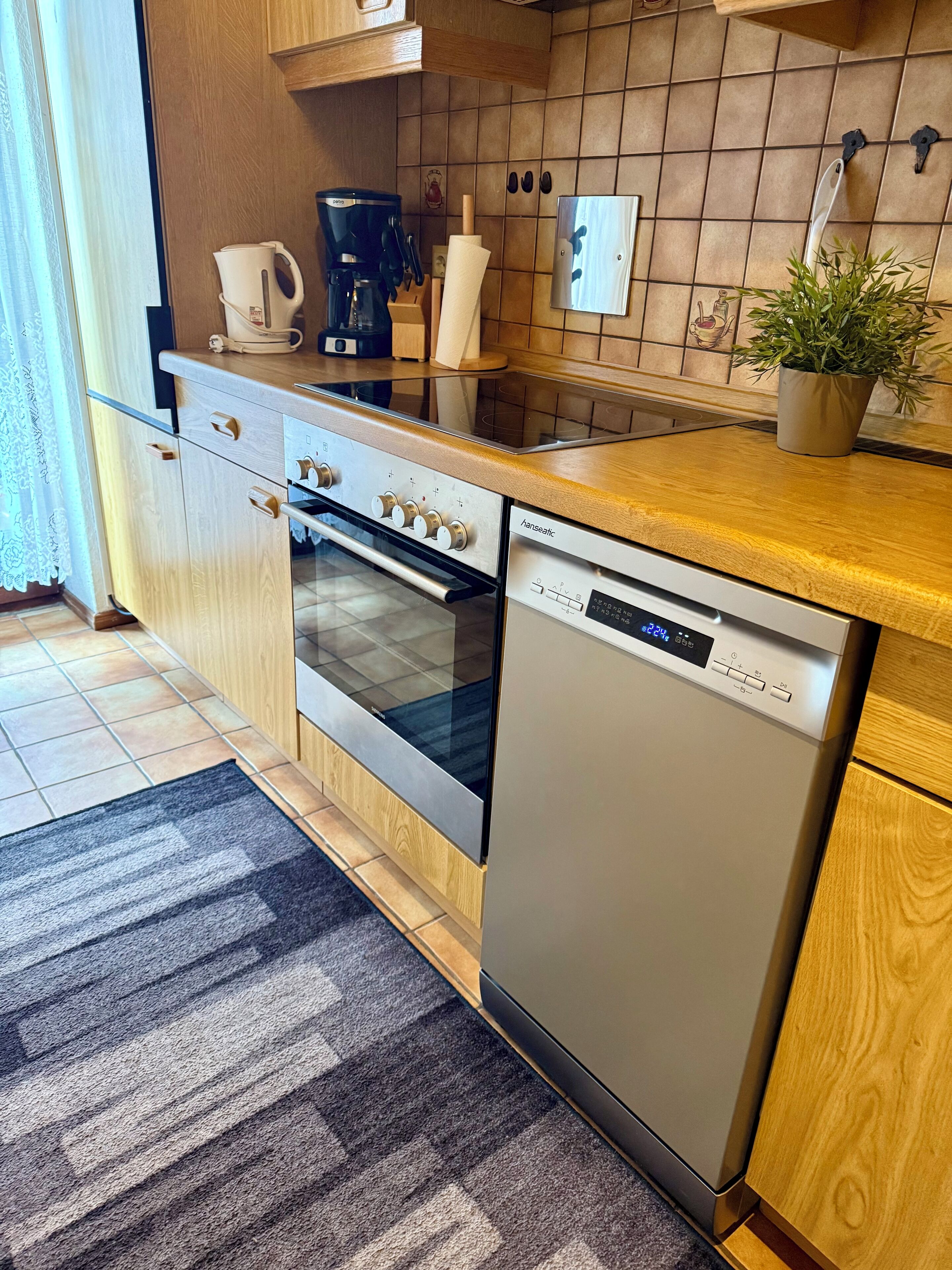 A modern kitchen with a built-in oven, dishwasher, and a coffee maker on the countertop.