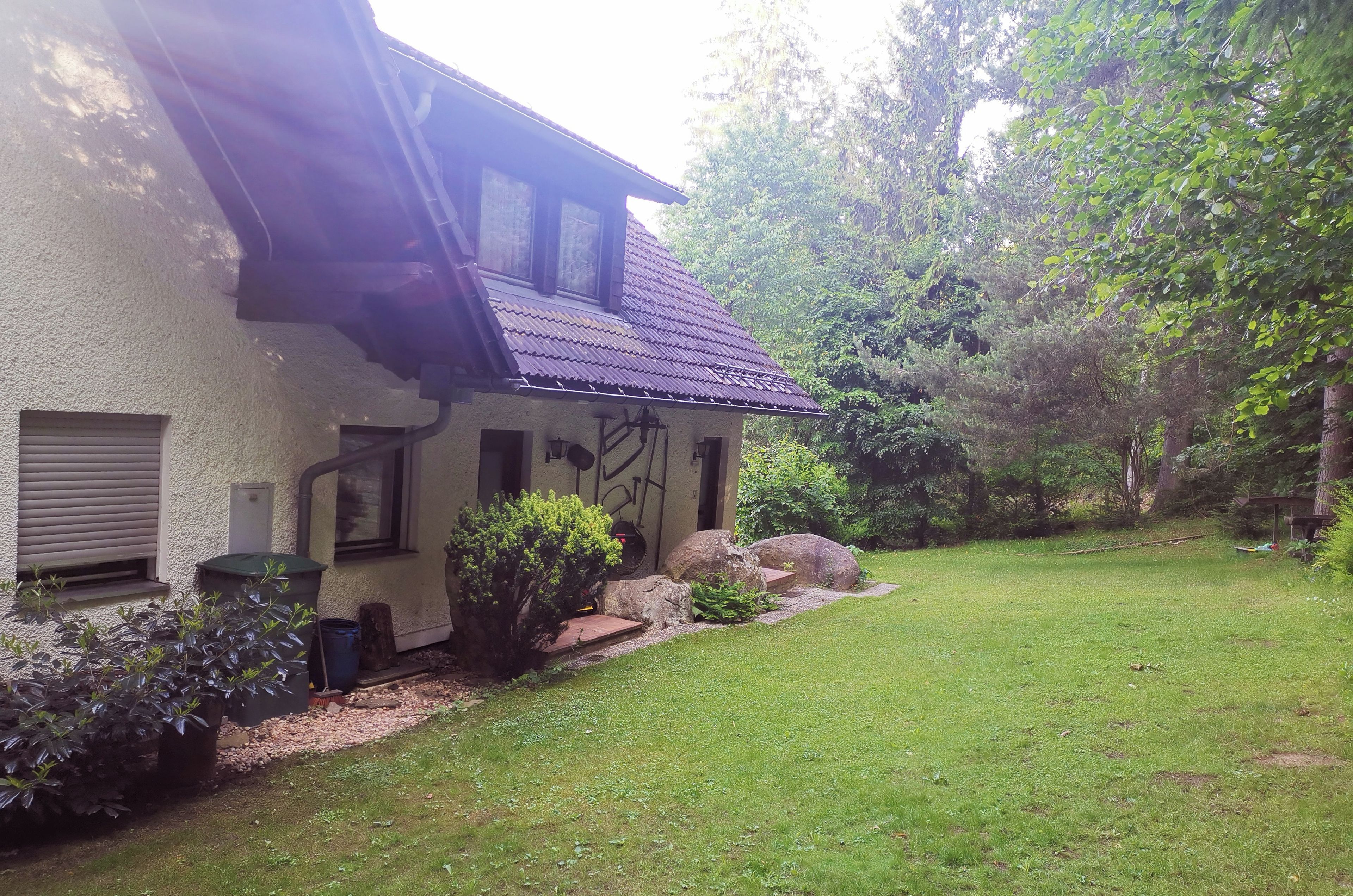 A house with a sloped roof, a small porch, and a well-maintained lawn.
