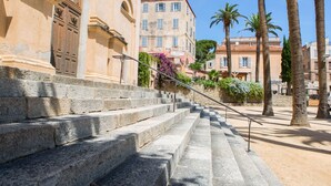A stone staircase leading up to a building with arched windows and a door.