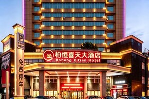 Un edificio de hotel con un cartel llamativo del Hotel Boheng Xitian.