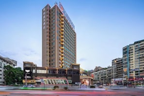 A tall hotel with multiple floors, a prominent entrance, and a modern design. - Boheng Xitian Hotel (Guiyang)