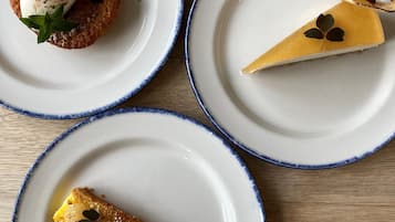 Three plates with desserts on a wooden table.