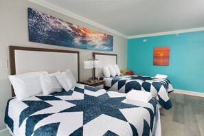 A hotel room with two beds, a nightstand, a lamp, and a large abstract painting on the wall.