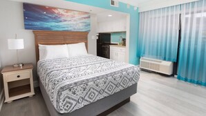 A hotel room with a large bed, a nightstand, a desk, a kitchenette, and a view of the outdoors. - Hot Tubs & Indoor Pools - First-Floor Privacy (Myrtle Beach)