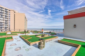 A rooftop garden with green turf, wooden play structures, and a view of the sea. - Hot Tubs & Indoor Pools - First-Floor Privacy (Myrtle Beach)