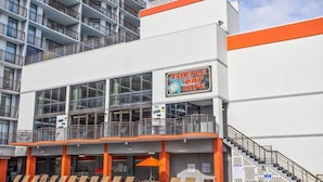 A multi-story building with a sign for 'Turtle Bay Cafe' and a pool area with lounge chairs. - Hot Tubs & Indoor Pools - First-Floor Privacy (Myrtle Beach)