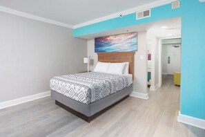 Een slaapkamer met een bed, hoofdeinde, een kunstwerk aan de muur en een deur naar een andere kamer.