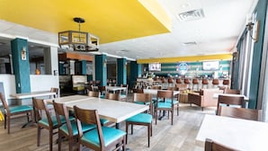 A restaurant with multiple dining tables and chairs, a kitchen area, and a counter. - Hot Tubs & Indoor Pools - First-Floor Privacy (Myrtle Beach)