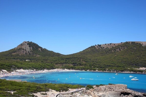 A coastal landscape with a beach, clear blue waters, and rocky hills. - Mar Azul Hotel - Adults Only (Capdepera)