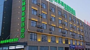 Un edificio di un hotel con diversi piani, condizionatori e finestre illuminate.