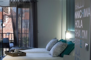 A hotel room with a bed, pillows, a tray with items, and a wall with text.