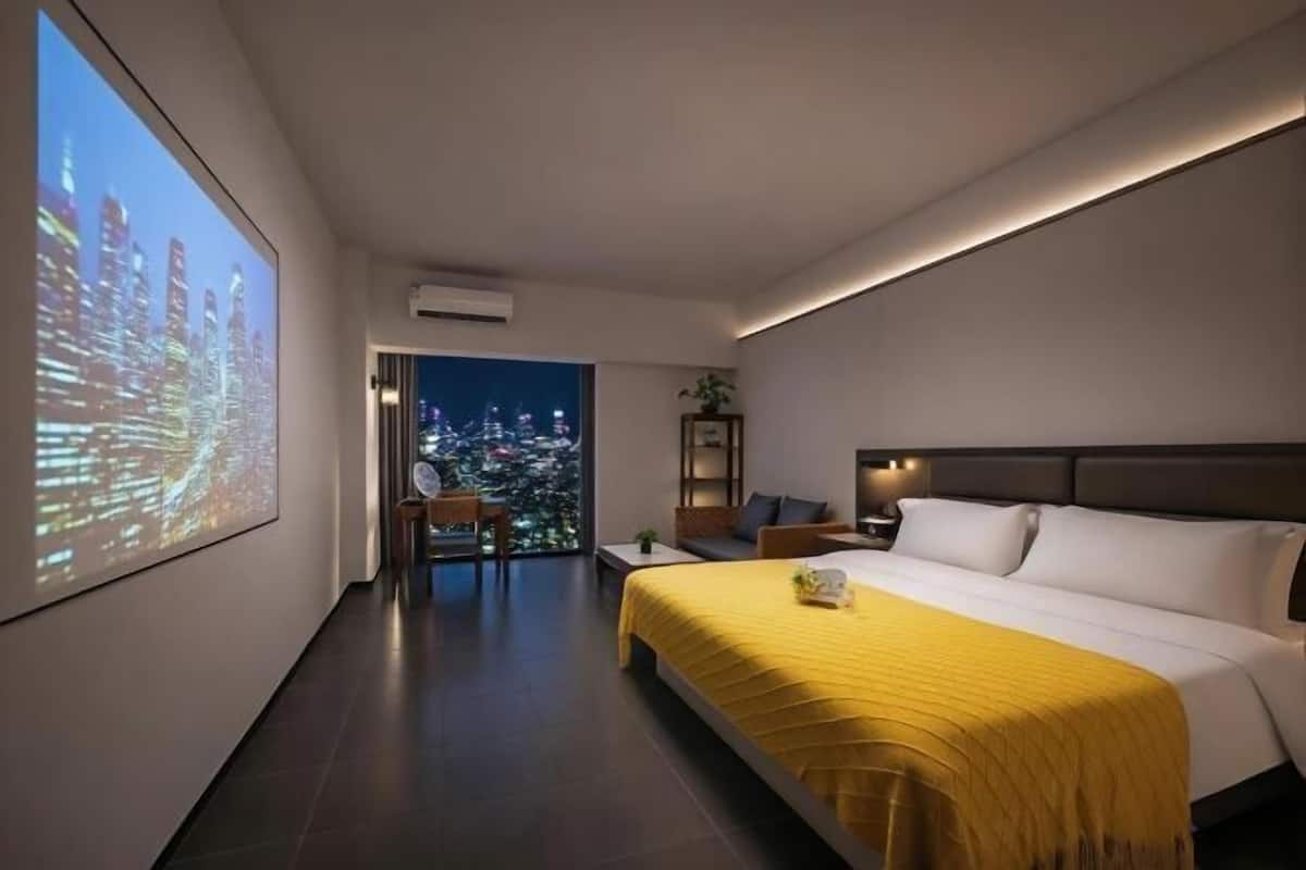 Een moderne hotelkamer met een groot bed, een stadsgezicht geprojecteerd op de muur en uitzicht over de stad door het raam.