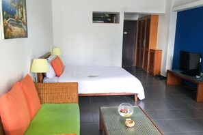 A hotel room with a bed, a sofa, a television, and a small table with a decorative item. - Shenlan Urban Hotel Apartment (Wanlvyuan Friendship Sunshine City Branch) (Haikou)