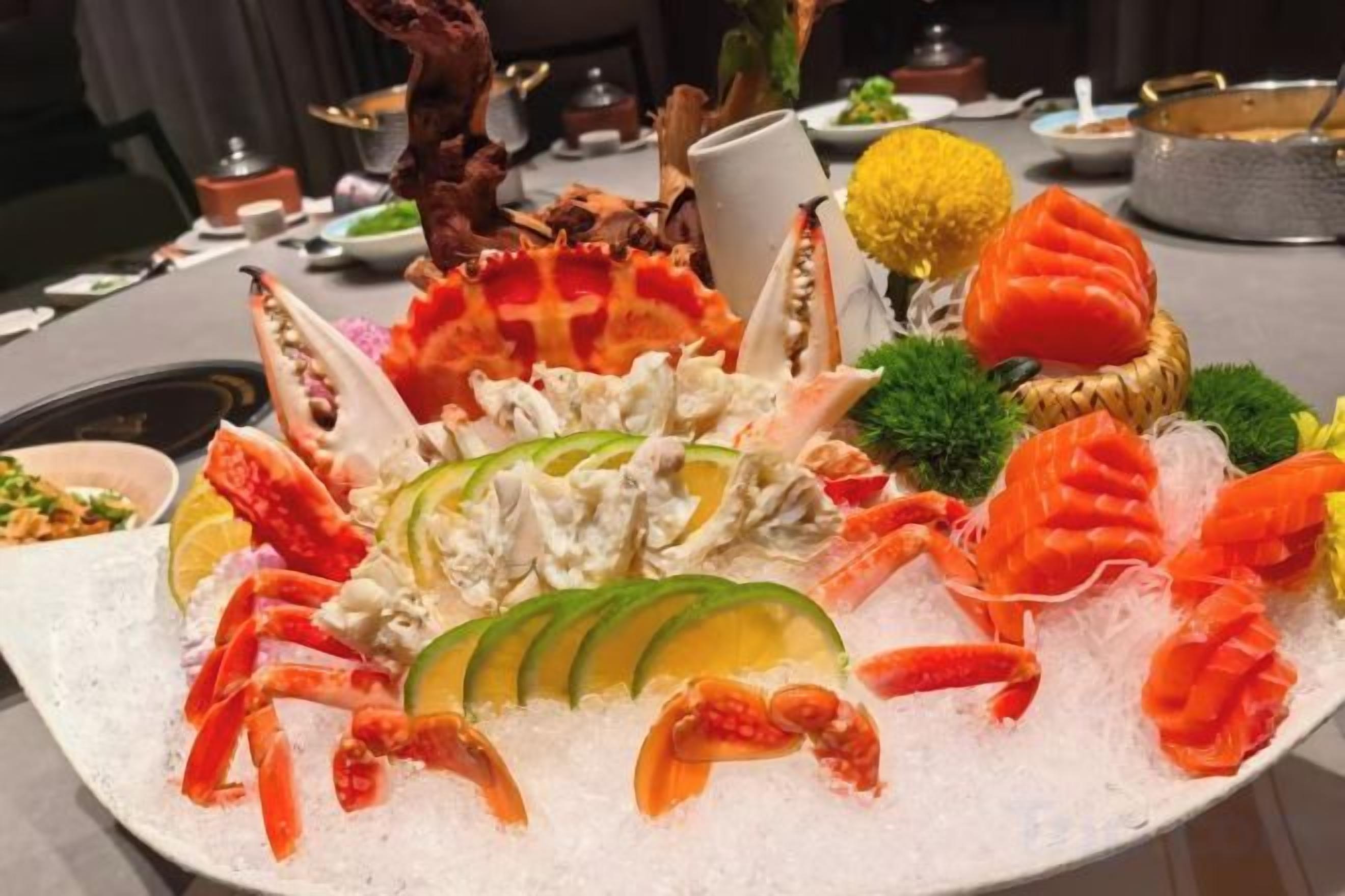A seafood platter with various types of seafood arranged on a bed of ice.
