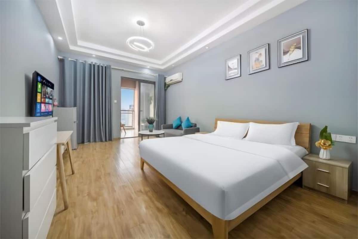 Een moderne hotelkamer met een groot bed, een bureau, een stoel en een televisie.