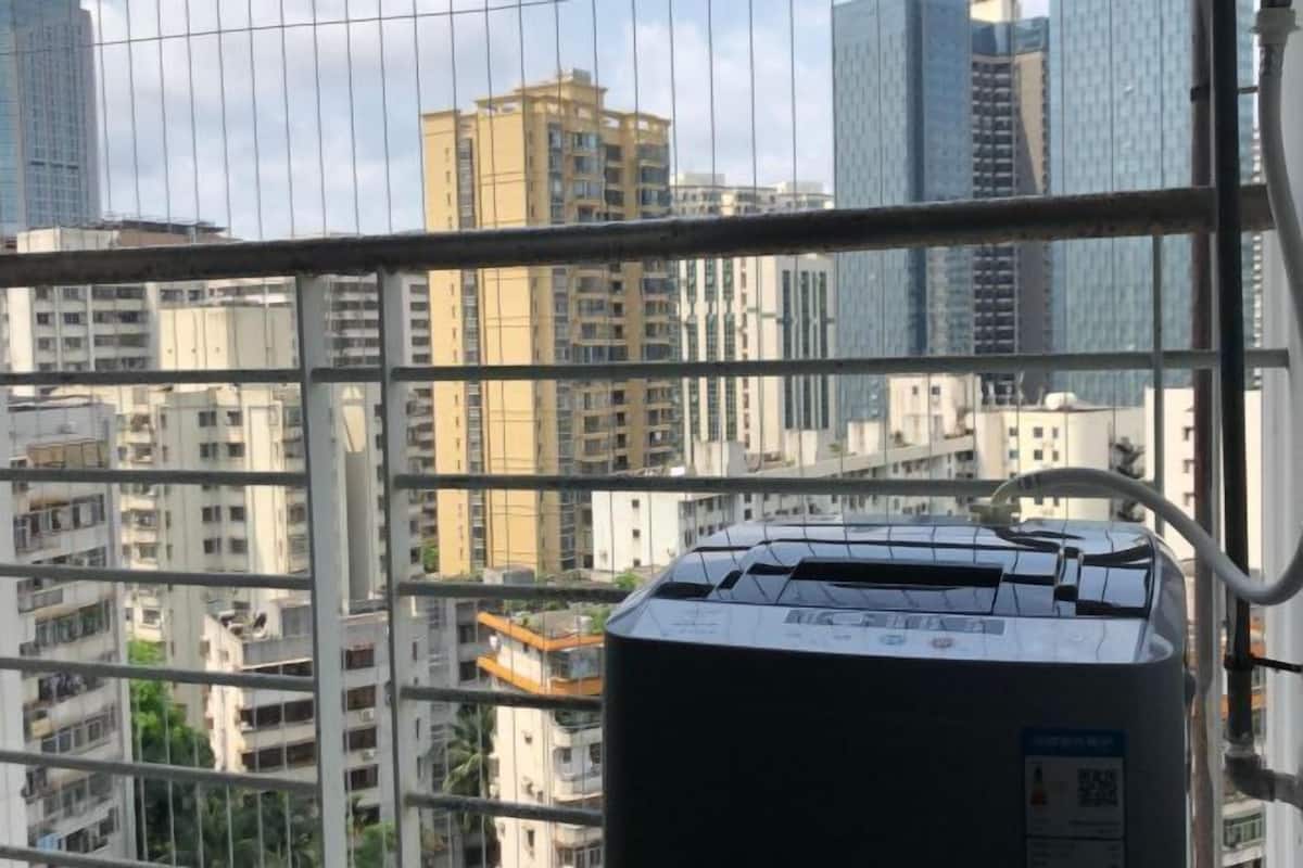 Een hoog gebouw met uitzicht op andere gebouwen door een raam.