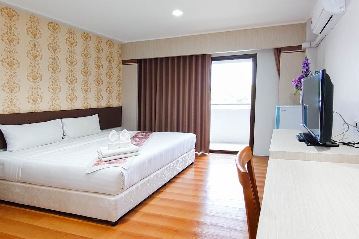 Una habitación de hotel con una cama, un escritorio con ordenador y televisión.