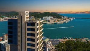 A hotel with multiple floors and a view of the sea and boats. - Hotel The Club Yeonhwari (Busan)