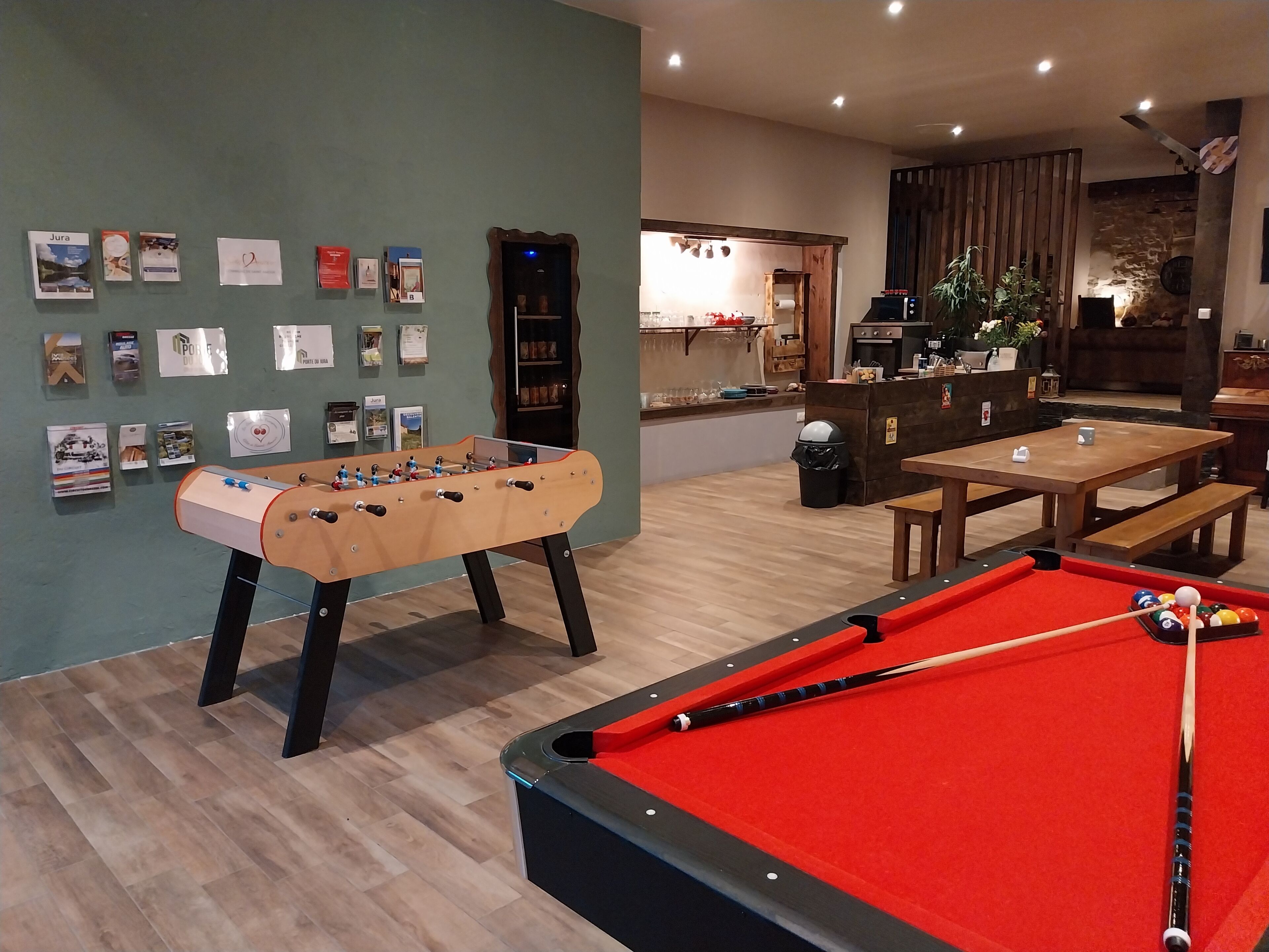 Una habitación con mesa de fútbol de mesa, mesa de billar y zona de bar.