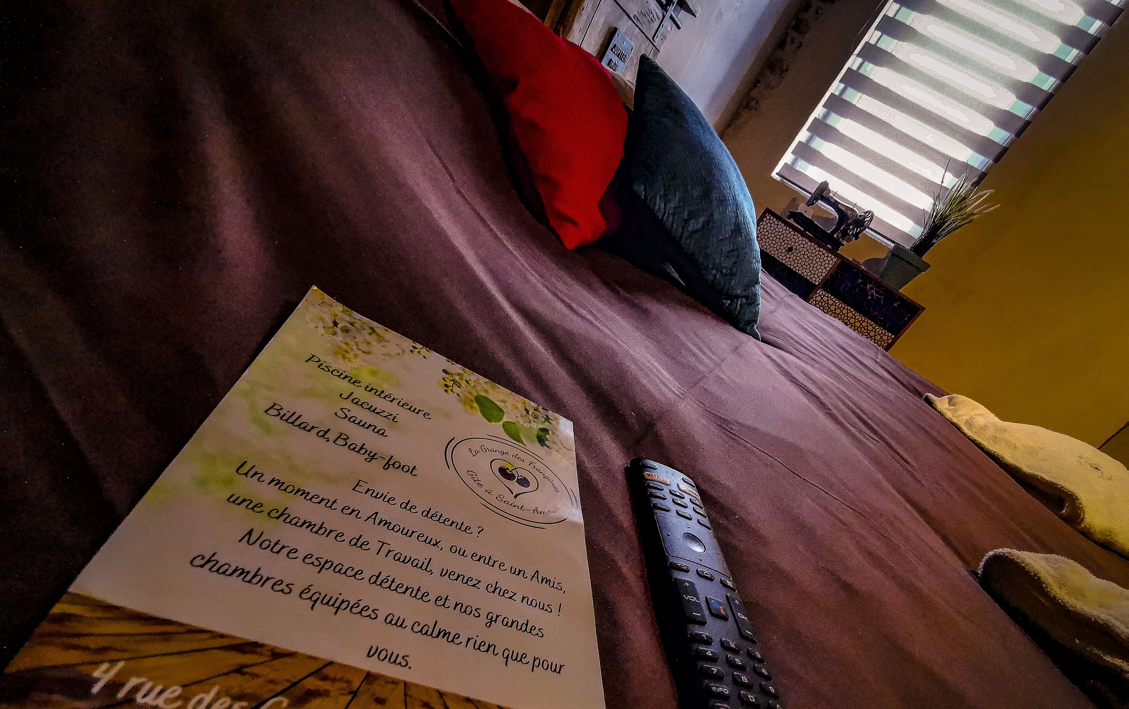 Ein Bett mit Fernbedienung und Speisekarten.