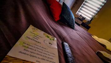 Ein Bett mit Fernbedienung und Speisekarten.