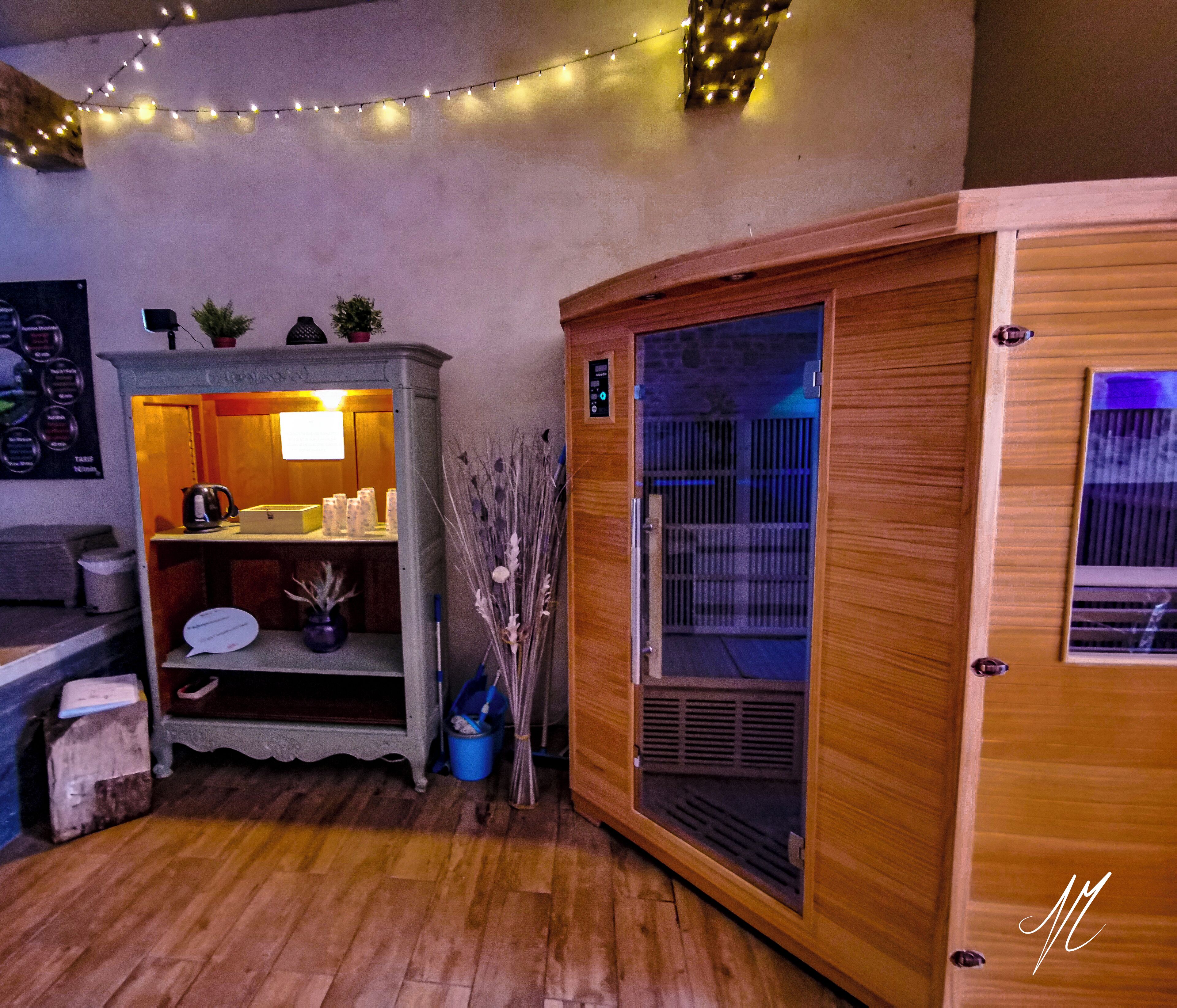 A room with a wooden cabinet, a shelf with a kettle, a blue bucket, and a broom.
