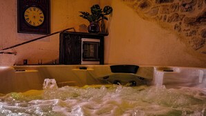 Een hottub met water, een klok en een plant op een plank.