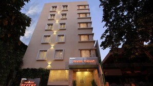 Un hotel con fachada moderna, varios pisos y una entrada bien iluminada.