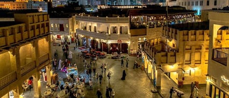 Una plaza animada con terrazas y diversos comercios.