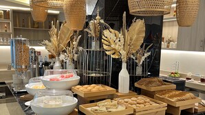Montaje de bufé con diferentes alimentos, elementos decorativos e iluminación colgante.