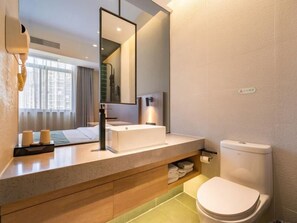 A modern bathroom with a large mirror, a white sink, a toilet, and a towel rack. - Greentree Inn Wuxi Quanshan Center Express Hotel (Wuxi)