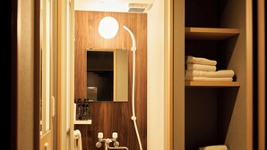 A wooden bathroom with a mirror, a towel rack, and a shelf with folded towels. - Boxi Hakata 1 -Sleep Hotel- (Fukuoka)