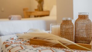 Una habitación de hotel acogedora, con una cama, una mesita de noche y dos jarrones de mimbre.