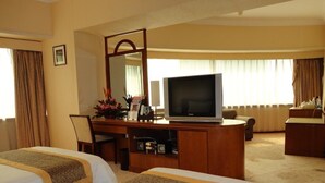 A hotel room with two beds, a desk with a television, a mirror, and a window with curtains. - Star Hotel (Guangzhou)