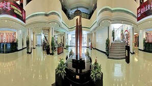 A spacious lobby with a central black sculpture, a staircase, and a reception area. - Star Hotel (Guangzhou)