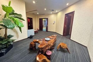 Une salle de conférence avec une longue table en bois, des chaises et une plante en pot.