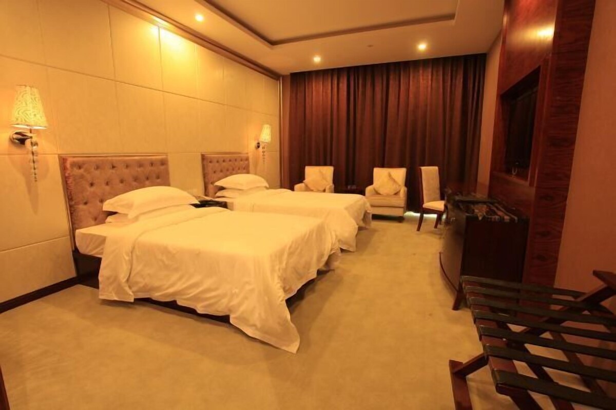 Una habitación de hotel con dos camas, un escritorio y una silla.