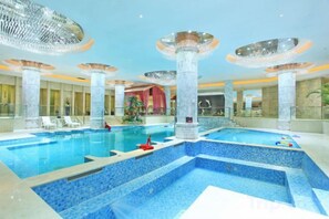 A large indoor swimming pool with multiple lanes, surrounded by columns and a ceiling with circular light fixtures. - Shuiyuntian Leisure Hotel (Jinshazhou) (Foshan)