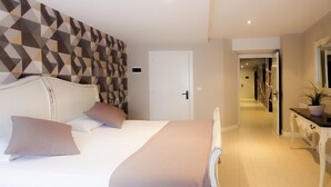 Una habitación de hotel con una cama, una mesita de noche, un espejo y una pared con estampado geométrico.