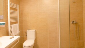 Un baño con inodoro, ducha y toallero.