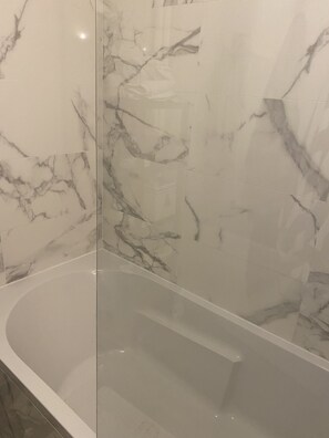 Banheira, secador de cabelo, toalhas de banho, papel higiênico