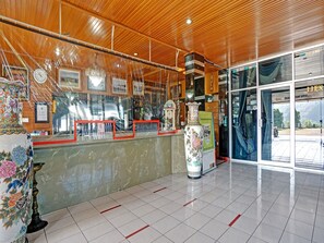 Un'area reception con soffitto in legno, un bancone in marmo e un vaso di grandi dimensioni.