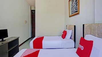 A hotel room with two beds, a TV, and a painting on the wall.
